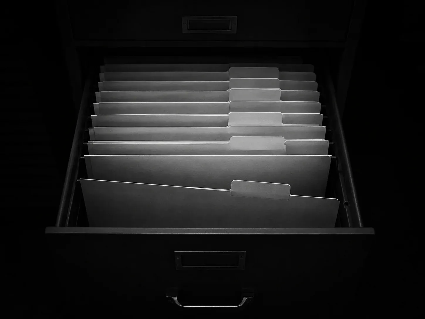 Cajón de archivo abierto con carpetas alineadas y una ligeramente adelantada